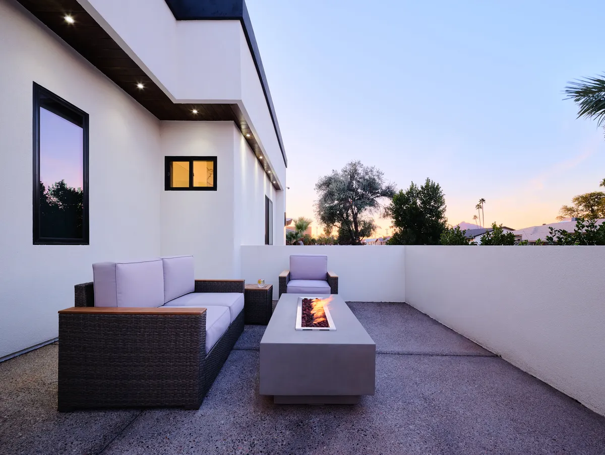 A cozy fire pit surrounded by modern seating and lush greenery. The atmosphere is intimate and inviting, perfect for evening gatherings and magical moments under the desert sky.